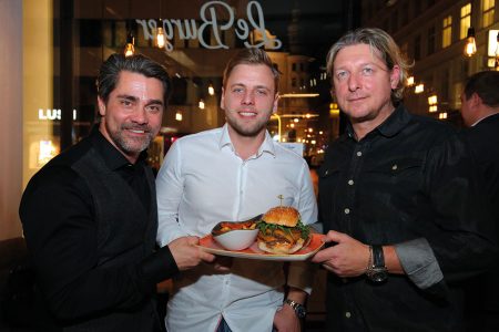 Moderator Andreas Seidl (l.) mit Le burger-Eigentümer Lukas Tauber (M.) und COO Ingo Faust bei der Eröffnung des neuen Stand­ortes