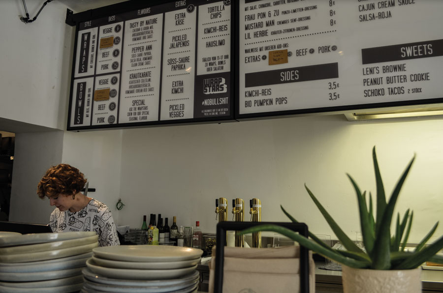 Bilder: Anja Schmidt Konzeption Küche Ehrliches, authentisches Fast Food: „Wrapstars“-Mitarbeiterin Sidonie beim Finishing der Speisen