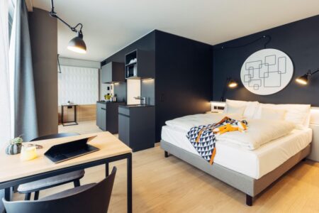 Dunklere Farbtöne und hochwertige Materialien kennzeichnen die Zimmer des neuen harry’s home Zürich-Limmattal in der Schweiz. 